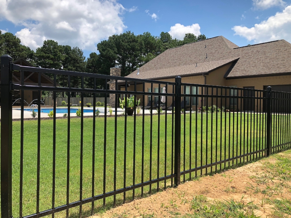 Steel fence extending perimeter of residential property in Conway with pool in background