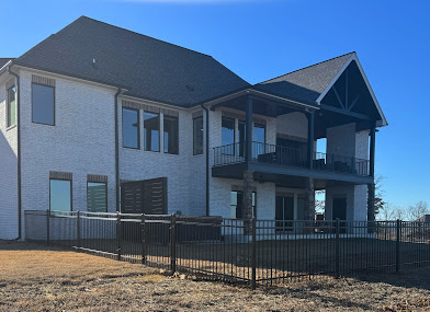 Steel Fence extending along two-story residential property's backyard in Central Arkansas